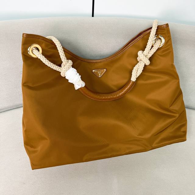 新款托特包1Bc244大购物袋 这款再生尼龙包袋灵感源自海洋风格的经典元素，采用新颖精美搭配，彰显活泼个性风格。滑动编绳手提柄为这款多功能配饰勾勒Oversiz