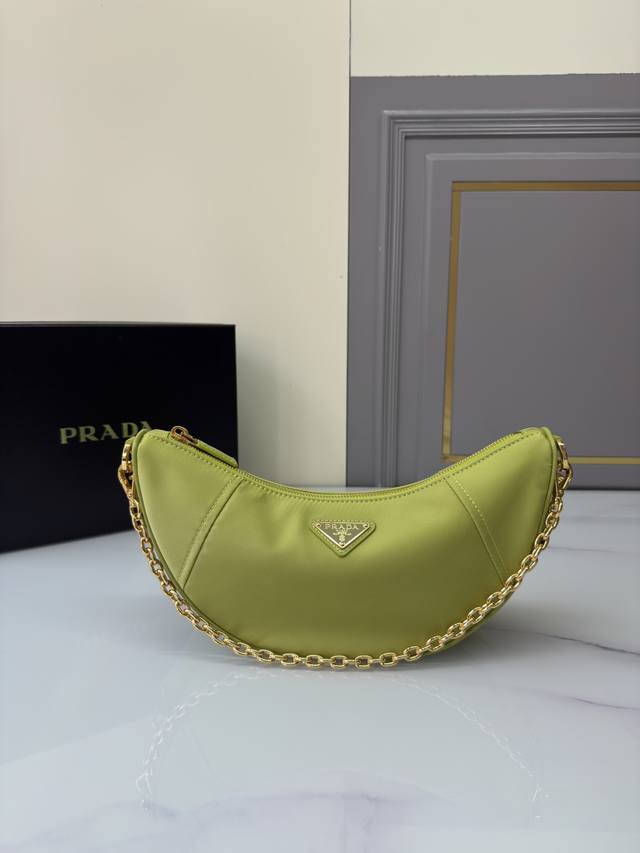 新品月牙包1Bh222多功能 这款Re-Nylon手袋采用再生尼龙面料制作，精致而百搭，融合档案库造型与实用的当代风格。半月廓形，搭配可拆卸运动风肩带与优雅的链