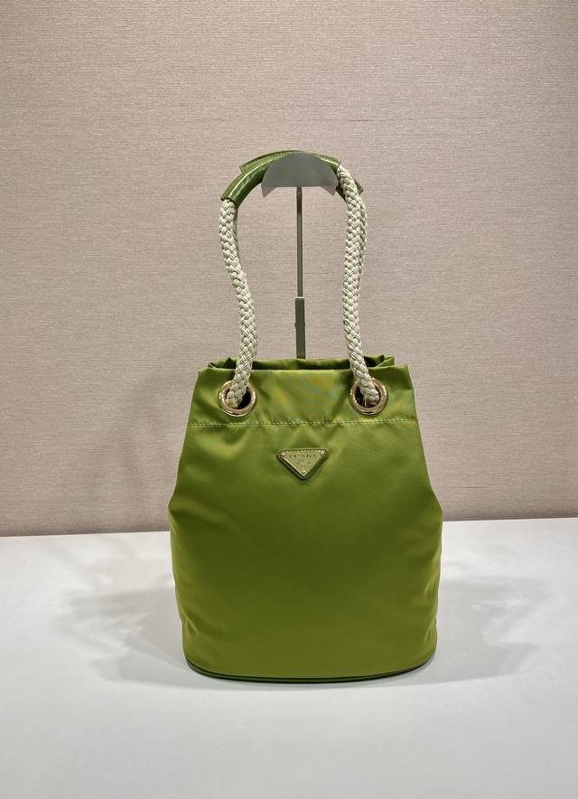 新款水桶包1Be082走秀款 这款Re-Nylon 手袋的設計采用尼龙面料和小牛皮。獨特的組合添上迷人點綴。滑動式繩索手挽凸顯這款手袋的靈活百搭，方便手提或肩背