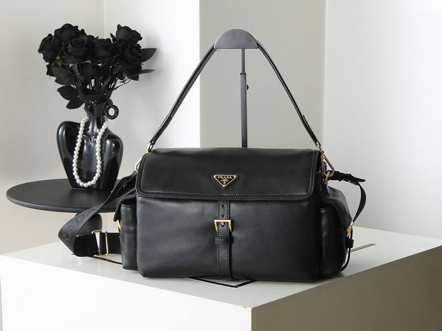 新款邮差包1Bd391大号 这款手袋完美融合精致与功能性，采用羊皮，配有多个口袋。轻盈实用的设计结合运动与百搭元素，饰有涂珐琅三角形金属徽标，搭配皮革细节。配有