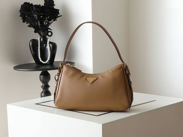 新款Aimee腋下包1Bc229小号 这款皮革Hobo腋下包设计气质简约，采用进口小牛皮，正面金属三角形珐琅徽标，配有可拆卸皮革肩带，皮质细腻柔软，实用轻便容量