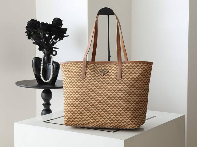 新款托特包1Bd552新品 这款Tessuto Triangulum托特包采用进口印花尼龙面料，配十字纹牛皮，三角形图案颜色吸睛夺目，容量空间大，真的巨能装上身