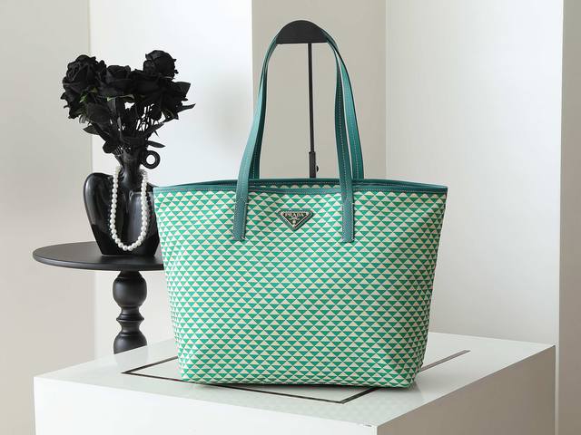 新款托特包1Bd552新品 这款Tessuto Triangulum托特包采用进口印花尼龙面料，配十字纹牛皮，三角形图案颜色吸睛夺目，容量空间大，真的巨能装上身