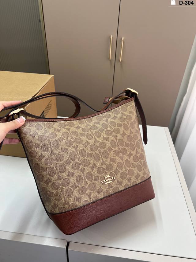 Coach蔻驰9月新品水桶包 肩带处选取一颗调节扣上显示了Tb家招牌Logo，显然这个设计做的更低调，适合商务人士。D-304尺寸24×26飞机盒