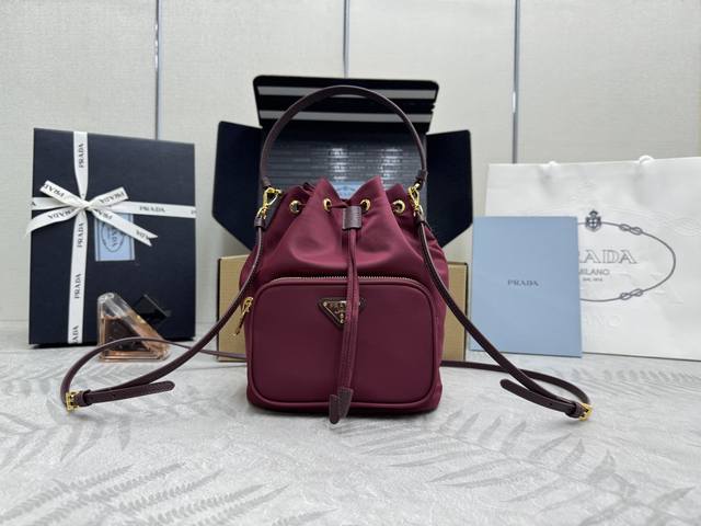 经典爆款1Bh038黑色到货了，水桶包采用进口尼龙布料，尼龙材质非常轻便耐用，可手提 斜跨，轻便又实用又时尚，功能设计性很强，有便于收纳的口袋。 长18X高23