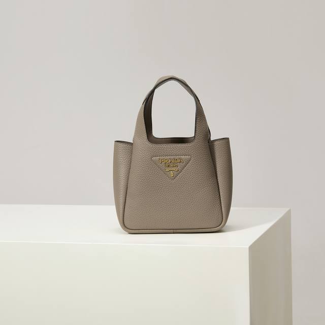 特级原厂 2025最新款菜篮子托特包迷你款1Ba349金扣 灰色 这款皮革迷你手袋采用解构廓形，以反向缝线诠释精美设计，打造柔和圆润的时尚造型。正面饰有金属字母