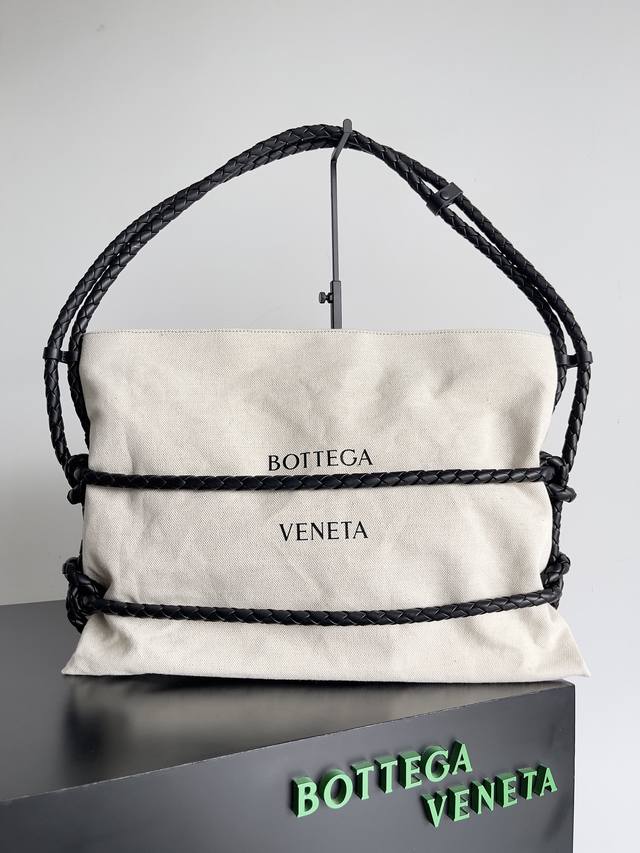 Bottega Veneta限量绳结帆布托特包 全国限定28只 这款托特包采用了品牌标志性的皮革编织设计包裹大身，黑色皮绳捆绑主整个包，一直延伸到肩带，这皮条可