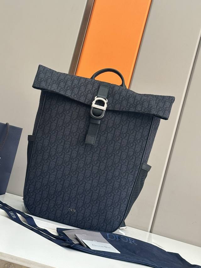 正品级 ，高版本 这款 Dior 8 卷顶双肩背包是二零二五春季男装系列新品，时尚且实用。采用黑色 Oblique 印花面料等材质精心制作，搭配带有 Dior
