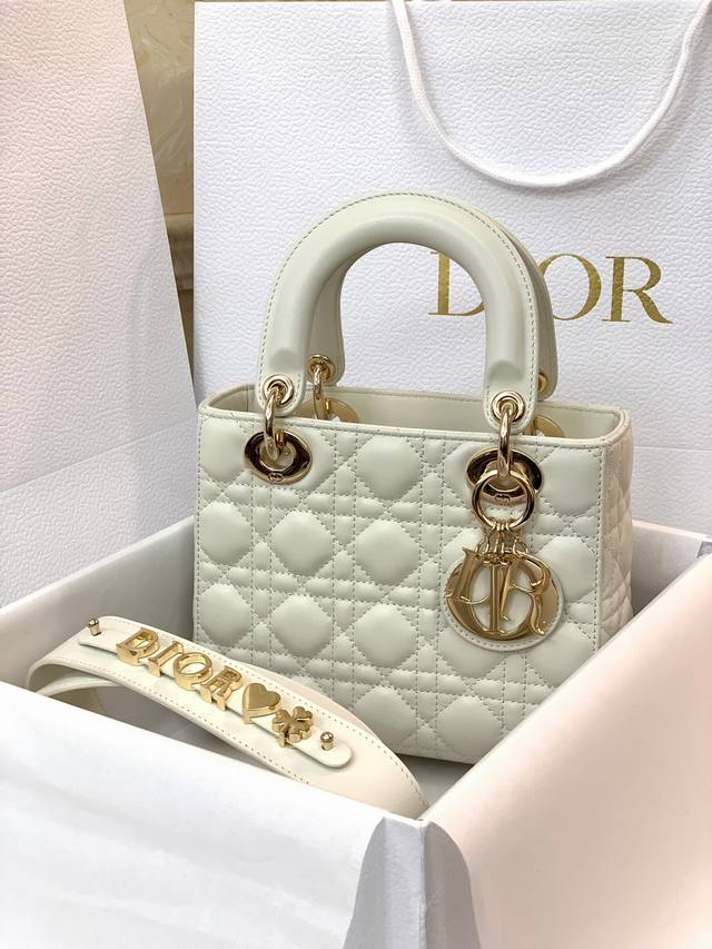 奶白色My Abcdior四格小羊皮藤格纹手提包,搭配可个性化宽肩背带,随赠6枚徽章,淡金色金属配饰,个性化宽肩背带,点缀Dior徽章,可手提亦可肩背或斜挎。 奶白色My Abcdior四格小羊皮藤格纹手提包,搭配可个性化宽肩背带,随赠6枚徽章,淡金色金属配饰,个性化宽肩背带,点缀Dior徽章,可手提亦可肩背或斜挎。