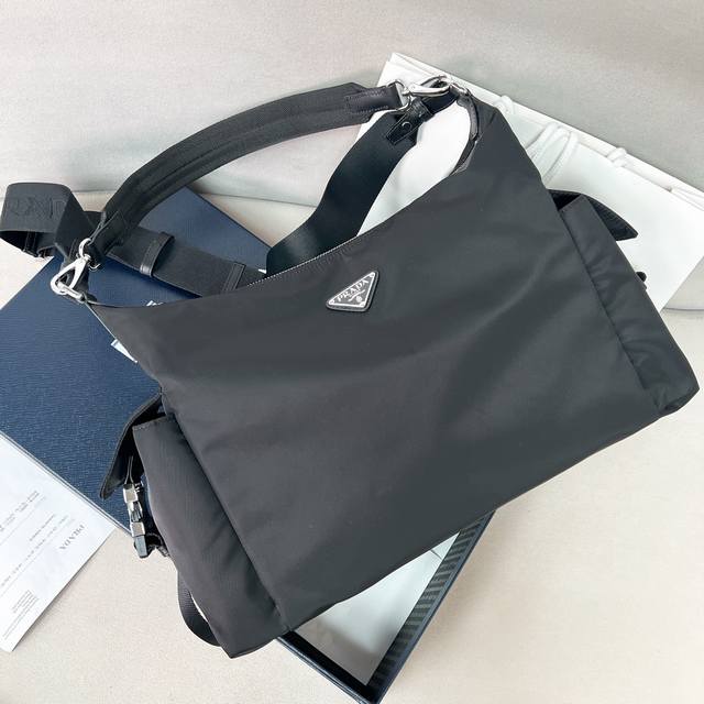 新品男款2Vh204探索包 这款Explore包是精致与功能的完美结合，体现了一种充满活力的现代风格。这款包袋重新诠释了尼龙面料的Hobo版型，配有2条可拆卸手