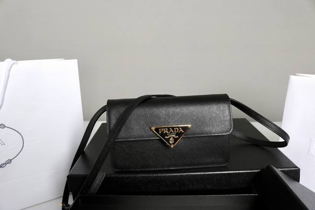 跑量价 简介：新品手袋 这款迷你手袋采用Saffano牛皮革打造。结构化的轮廓配有内部口袋和卡槽，并以金属标志性的三角形装饰闭合处。配有一条可调节可拆卸的长肩带