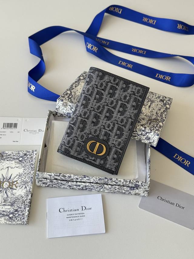 护照夹 这款护照套实用而高雅。采用米色和黑色 Oblique 印花面料精心制作，正面饰以 Dior 标志，内部为黑色光滑牛皮革材质。设有两个票据隔层，一个登机牌
