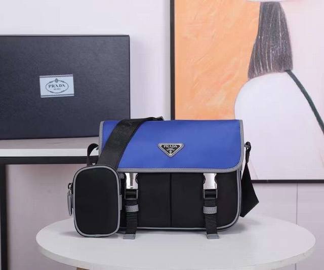 新色2Vd769B原单货这款尼龙翻盖手袋饰有经典的Saffiano皮革饰边，配有两枚旁开扣，并饰有标志性的三角形金属徽标，彰显时尚设计格调，采用进口尼龙和Saf