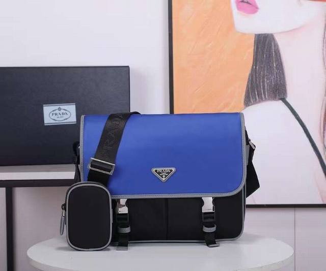 2Vd768B原单货这款尼龙翻盖手袋饰有经典的Saffiano皮革饰边，配有两枚旁开扣，并饰有标志性的三角形金属徽标，彰显时尚设计格调，采用进口尼龙和Saffi