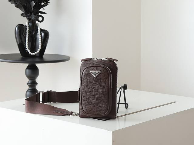 新品手机包2Vh195 这款多功能现代智能手机壳选用鹿皮革制成，利落时尚。配有多个拉链口袋与可调式肩带，饰有涂珐琅三角形金属徽标。卡糟格层设计得非常实用，又是一