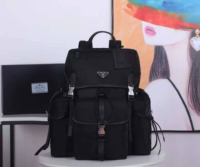 新款双肩背包2Vz074背包 采用Saffiano皮革饰边的织物面料制作，呈现兼具功能性和现代感的设计特色。背包配有多个口袋，撞色色调和对比鲜明的材质跃然包身，