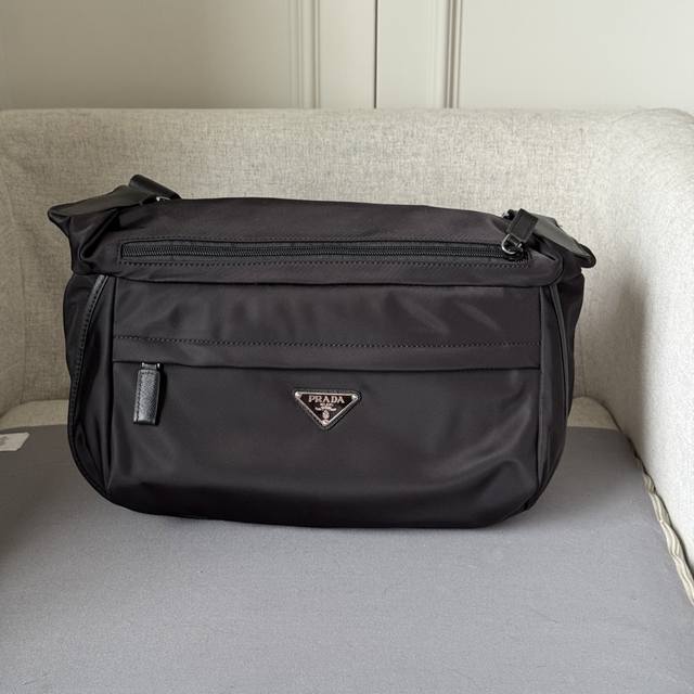 经典邮差包2Vh991A 这款翻盖式单肩包采用尼龙和Saffiano皮革等标志性的p家材质制作。单肩包配有内部和外部口袋，并饰有三角形金属徽标，兼具功能性与品牌