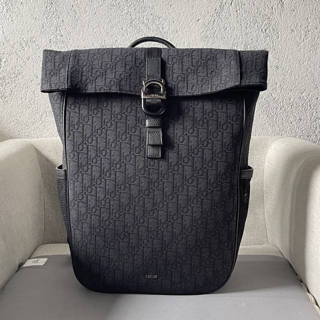 这款 Dior 8 卷顶双肩背包是二零二五春季系列新品，时尚实用。采用黑色Oblique 印花面料精心制作，搭配带有Dior 8搭扣的自扣式翻盖提升格调，正面饰