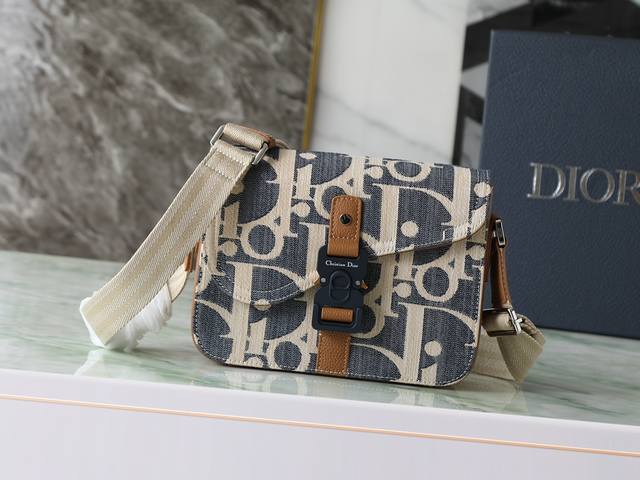 这款马鞍信使包款式时尚精巧。采用酒椰草效果Oblique 印花牛仔面料等材质精心制作，饰以蓝色提花刺绣，点缀以对比鲜明的米色缝线，全新演绎Dior经典款式。饰以