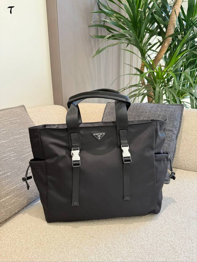 prada再生尼龙托特包 国prada这款再生尼龙托特包，采用环保材质，轻便耐用.还防水0。简约大气设计，正面有经典三角徽标，辨识度超高+。尺寸约40X35Cm