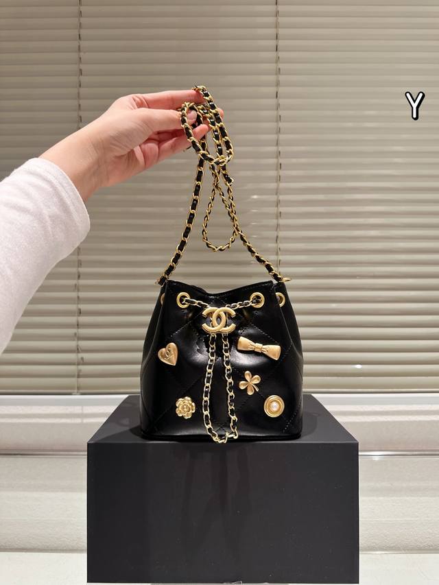 牛皮版本 Chanel 25K 抽绳水桶包 Chanel 25K抽绳水桶包，黑色荔枝纹牛皮＋金属链条，优雅又实用！包身点缀金色双C Logo、心形和蝴蝶结，细节