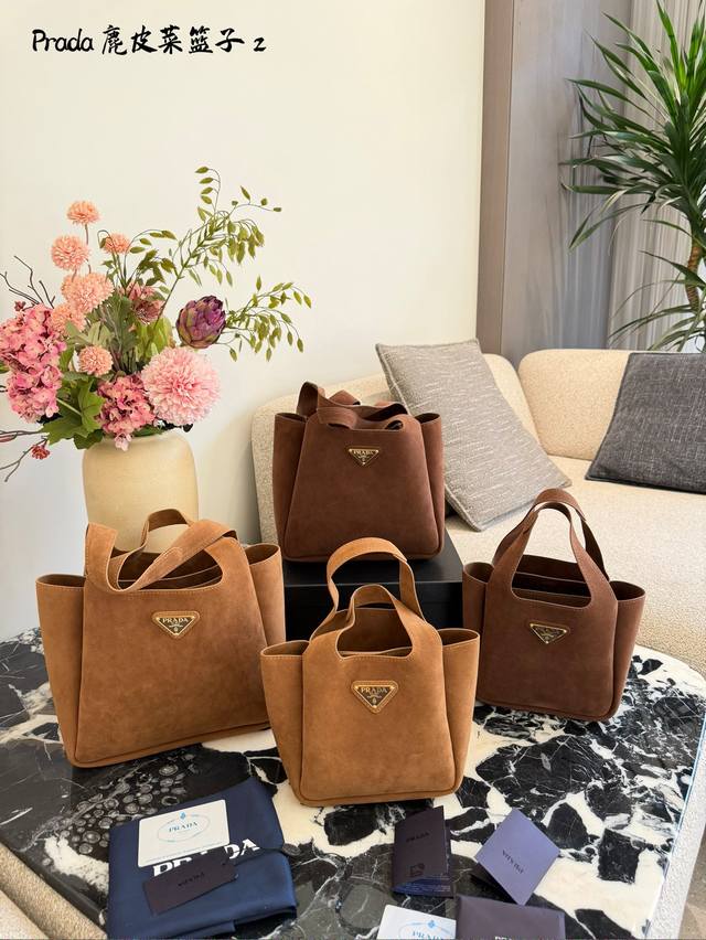 prada菜篮子水桶包 秋冬季麂皮手袋，里外全皮配 菜篮子水桶包 秋冬季麂皮手袋，里外全皮配有双提手饰以金属徽标，整体包身非常柔软轻巧，格调优雅出类拔萃，两个侧