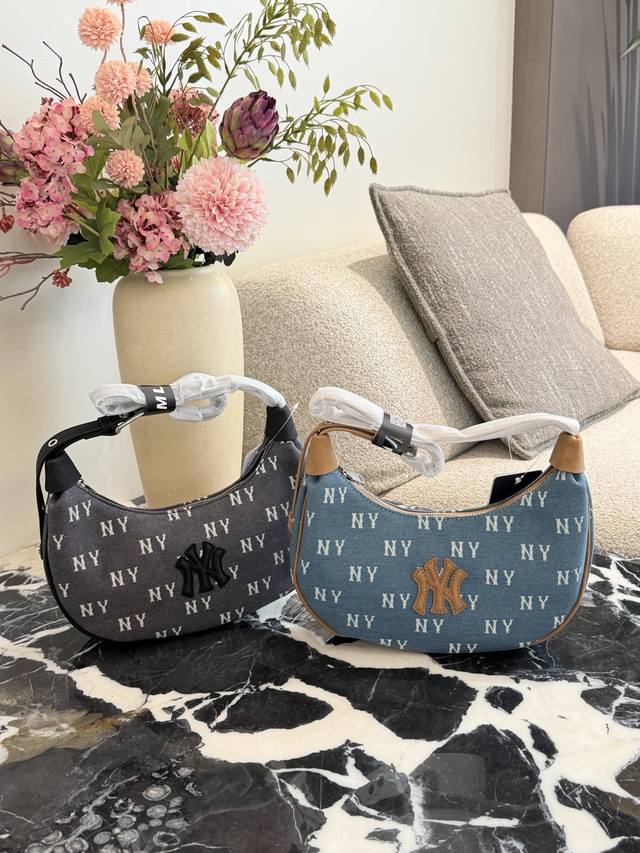 Mlb丹宁老花腋下包 ▼Ml _B丹宁老花腋下包，经典Ny满标设计，丹宁布料+棕色皮质肩带，复古又时髦+。包身小巧，拉链开合，日常通勤、休闲出行都很适合。内部空