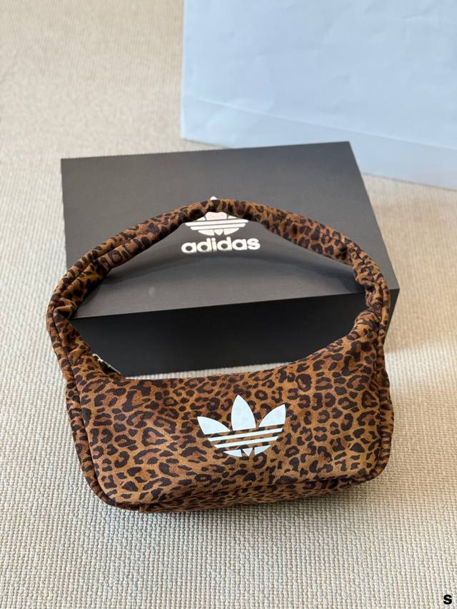 阿迪达斯三叶草豹纹腋下包 阿迪达斯三叶草系列豹纹腋下包，帆布材质+经典豹纹，搭配白色三叶草标志，复古又时髦。包型小巧，容量适中，手机、雨伞、小风扇都能装下，通勤
