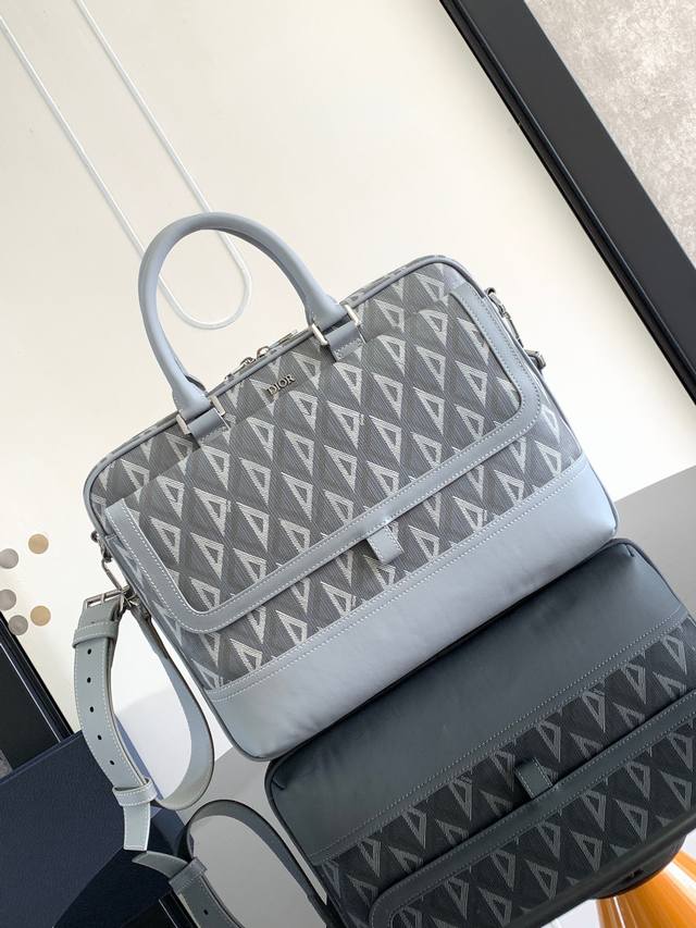 背景原厂 。这款 Dior Hit The Road 公文包是二零二三夏季新品，将现代风格与 Dior 的高订精神融为一体。采用灰色 Cd Diamond 图案