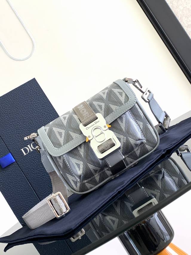 背景原厂 。这款 Dior Hit The Road 手袋是二零二三春夏成衣系列新品，将现代风格与 Dior 的高订精神融为一体。采用迪奥灰 Cd Diamon