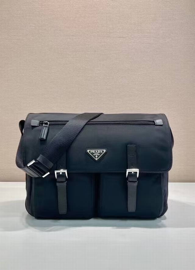 新款邮差包1Bd672 DDD 采用进口尼龙布料和小牛皮，可调式织物肩带 不锈钢配件 三角形珐琅徽标铭牌 拉链和搭扣开合 两个外袋，其中一个翻盖拉链袋 两个内袋