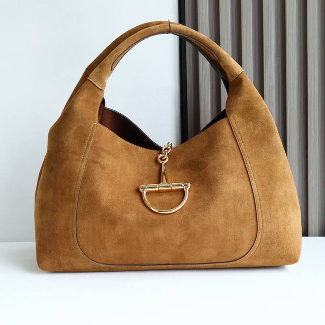 这款Gucci Softbit系列肩背包匠心融蕴大号半马衔扣造型品牌经典马术风格配件。这款大号肩背包搭配可拆卸手拿包。 DDD 棕色绒面材质 DDD 浅金色调配