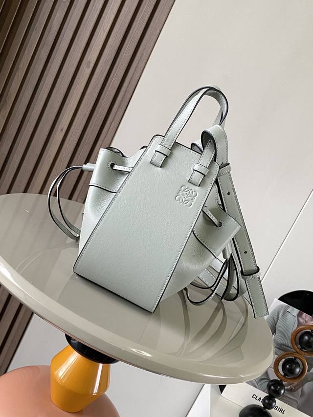 原厂皮 迷你柔软粒面牛皮革 Hammock 抽绳袋带有柔软侧面抽绳包身的多功能手袋可释放侧面抽绳来改变形状。环状带子可以使手袋有多种佩戴方式这个迷你版本采用柔软