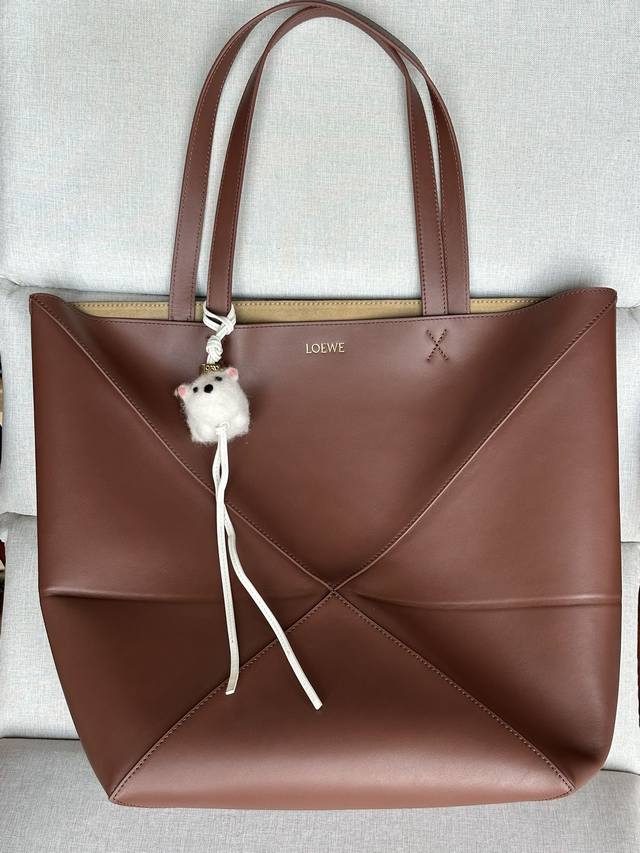 原厂皮 型号1761 大号 Puzzle Fold 大号 布尼棕 亮面牛皮手袋从品牌经典手袋系列的几何线条汲取灵感，运用创意巧思将其重新诠释为一款时尚的托特手袋