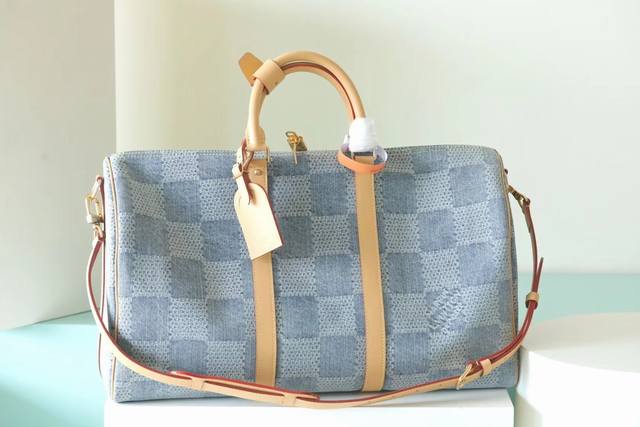 顶级原单 N40739本款 Keepall Bandoulière 50 旅行袋以 Damier Denim 3D 棉质帆布释放夏日气息。棉布经过匠心裁切、漂白