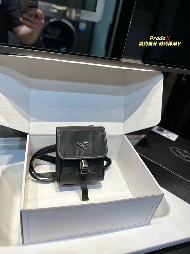 礼盒包装 普拉达prada新款多功能机能包 这款re-Nylon再生尼龙和 Saffiano 皮革男士机能包线条简约，然又不失多功能性。外侧口袋配搭鲜明的科技旁