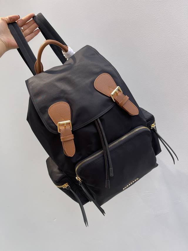 B家纯原 The Rucksack 军旅背包 为时装秀主打配饰，款式轻便且防水，焕新精选拼色尼龙材质，搭配经典条纹肩背带，其柔软休闲的包型可追溯至 20 世纪初