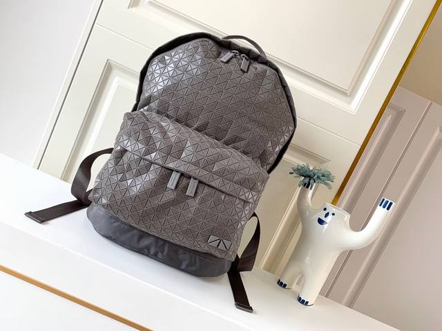 Issey Miyake Bao Bao 经典kuro系列休闲背包质感柔韧的小三角片，采用轻薄硅胶材质，摒弃了传统背包的厚重感，加上网状背带设计，舒适透气，轻巧