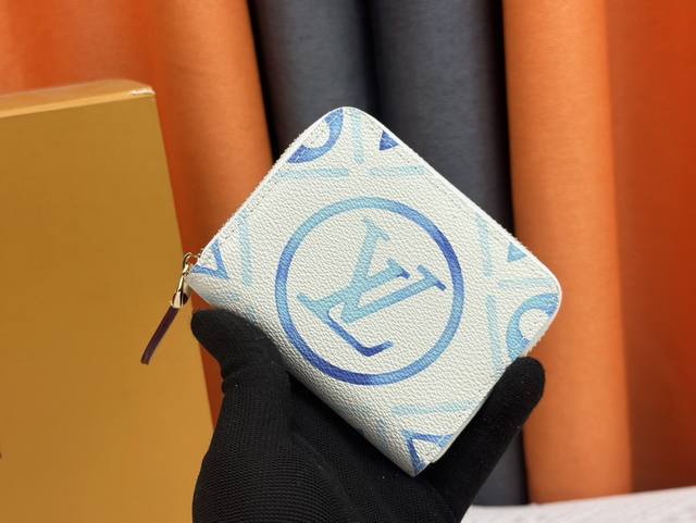 M83658蓝色 这款季节性的 Zippy 硬币钱包属于 Lv By The Pool 系列，该系列让人联想起异国情调的目的地。它采用涂层帆布制成，带有色彩缤纷