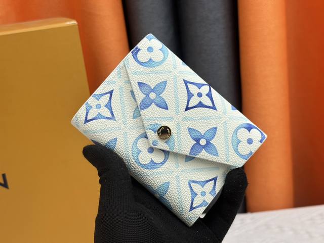 M83623蓝色 对于 Lv By The Pool 夏季系列，Victorine 钱包在涂层面料上重新诠释，印有活泼的 Monogram Tiles 印花，灵