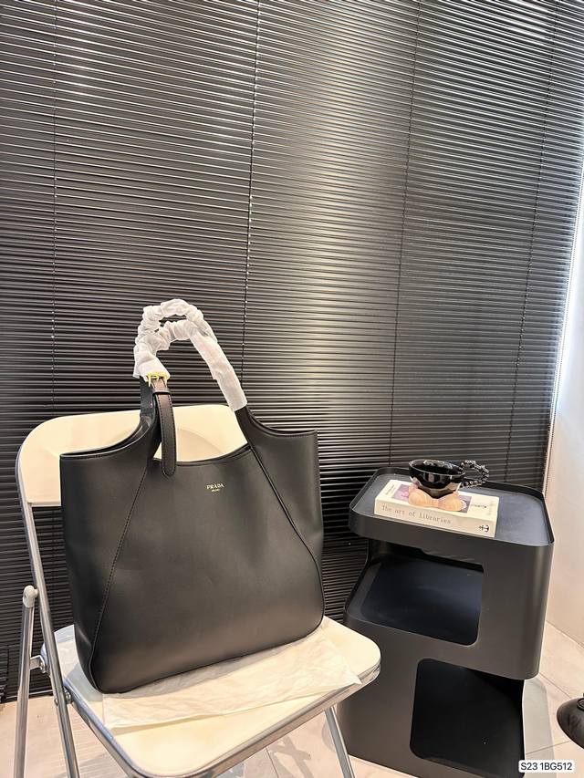 普拉达托特包既充满精致魅力，又富有实用性。搭配可调节皮革提手，饰有经典设计的金属扣环，呈现出时尚而现代的细节。尺寸37 30 货号1Bg512