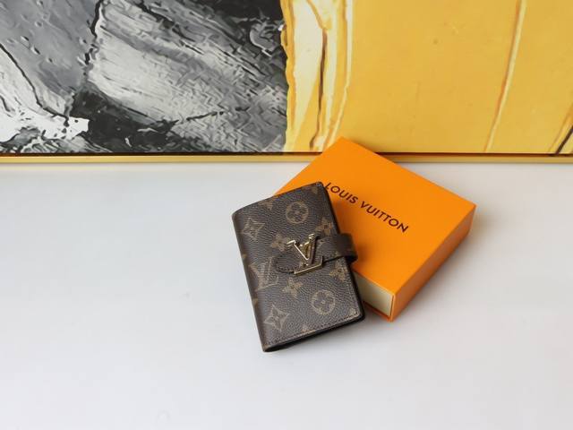 颜色 老花尺寸 12X9Lv Vertical C 钱包采用精美粒面 Taurillon 皮革制成，配有撞色衬里。滑动式 Lv 首字母搭扣让人想起标志性的 Ca