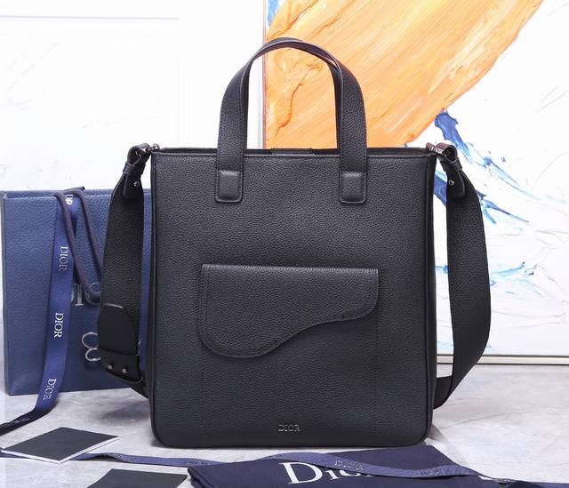 顶级原单 这款马鞍手袋以时尚优雅的轮廓彰显经典魅力。采用黑色粒面牛皮革精心制作，主隔层宽敞，正面翻盖口袋彰显标志性的马鞍轮廓。搭配顶部手柄和可调节肩带，可手提或