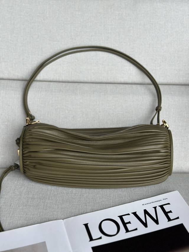 原厂皮 褶皱纳帕皮革手链小包 9751 颜色: 深卡綠 这款多功能管状小包采用褶皱纳帕羊皮革制成，可转换为手链佩戴。 两端都饰有压纹羊皮革饰板。 可拆卸可调节带