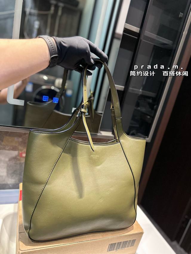 普拉达这款皮革托特包采用进口小牛，内配进口羊皮，既充满精致魅力，又富有实用性。搭配可调节皮革提手，饰有经典设计的金属扣环，呈现出时尚而现代的细节。尺寸37*30