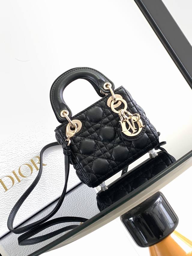 这款 Lady Dior 超迷你手袋集中体现了 Dior 对优雅和美丽的深刻洞见。采用黑色羊皮革精心制作,饰以藤格纹缉面线,搭配 D.I.O.R. 吊饰,为精美 这款 Lady Dior 超迷你手袋集中体现了 Dior 对优雅和美丽的深刻洞见。采用黑色羊皮革精心制作,饰以藤格纹缉面线,搭配 D.I.O.R. 吊饰,为精美
