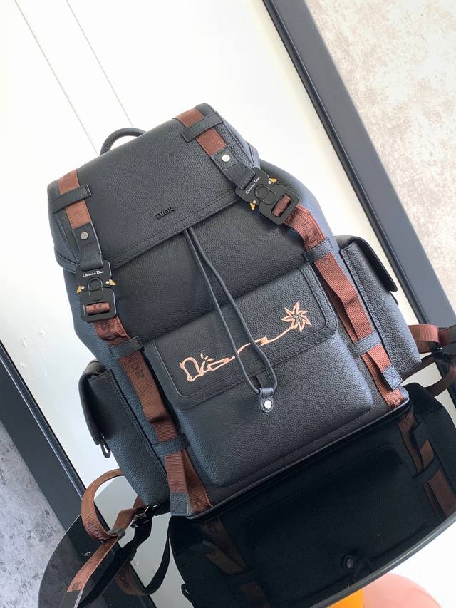 这款 Dior Hit The Road 双肩背包是本季的新款单品，来自 Dior 与 Cactus Jack 的尊享联名系列。采用黑色粒面牛皮革精心制作，正面