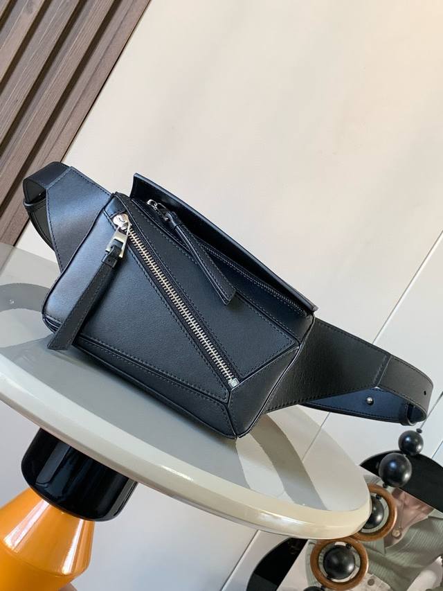 迷你号经典牛皮革 Puzzle 腰包长方体形状和精确的切割技术创造了puzzle 独特的几何线条这款小迷你号腰包采用经典牛皮革制成皮质柔软轻便，造型低调有辨识度