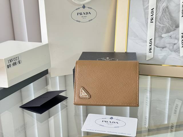 Prada 新款上线了 按扣式开合短夹， 男女通用，型号1Mv021， 颜色如图所示 一个钞票隔层，四个卡槽，两个内部口袋，另外还有一个拉链式口袋 十字纹牛皮制