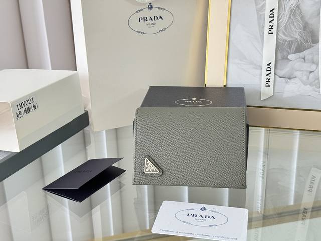Prada 新款上线了 按扣式开合短夹， 男女通用，型号1Mv021， 颜色如图所示 一个钞票隔层，四个卡槽，两个内部口袋，另外还有一个拉链式口袋 十字纹牛皮制